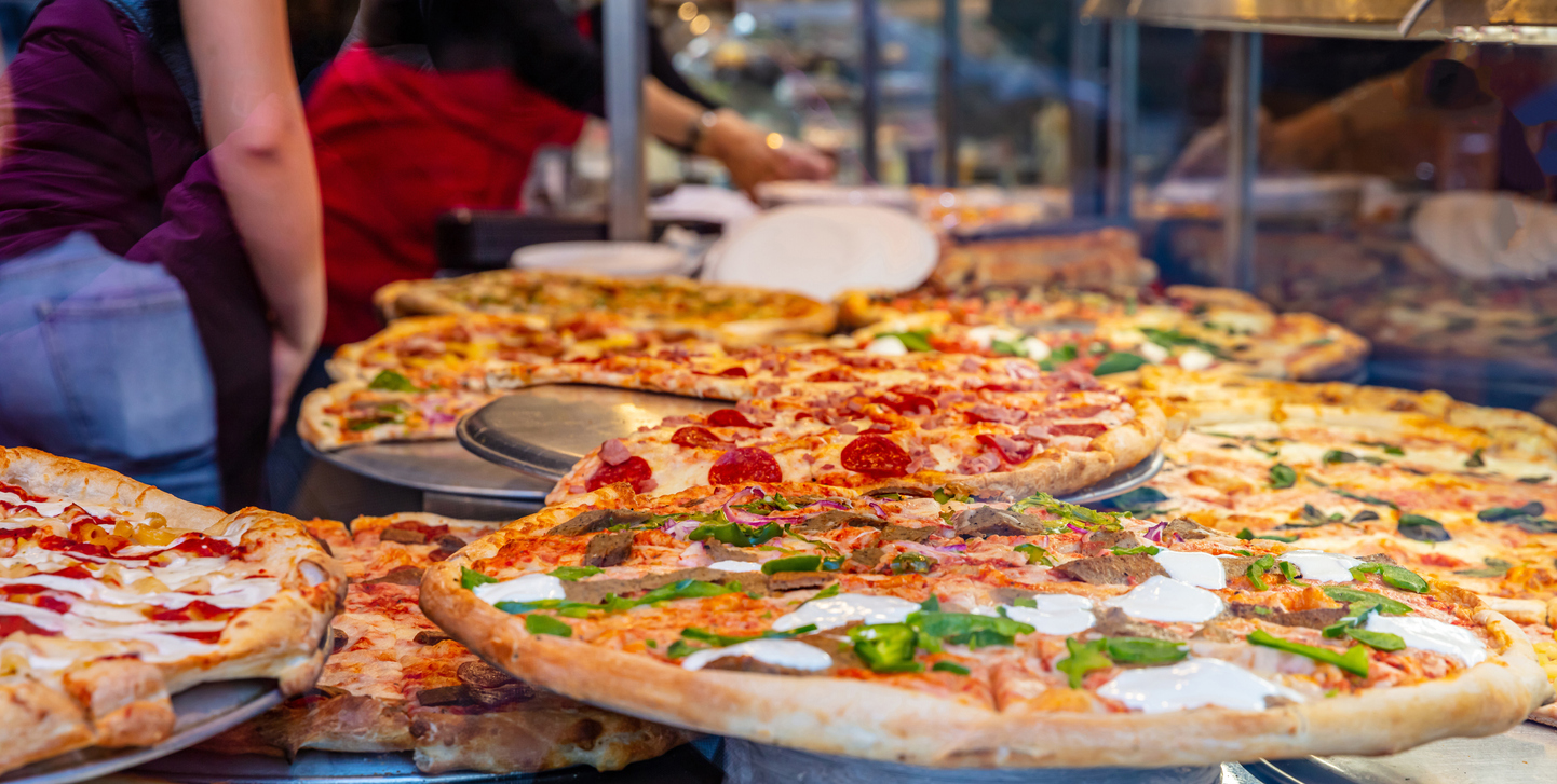 Pizzeria glass window. Variety of italian pizzas in a shop display, street food. Kitchen workers arranging the pizzas. This represents a pizza festival that Dave Portnoy puts on. He's a controversial figure and brands and sponsors have to see if he's worth the brand risk.