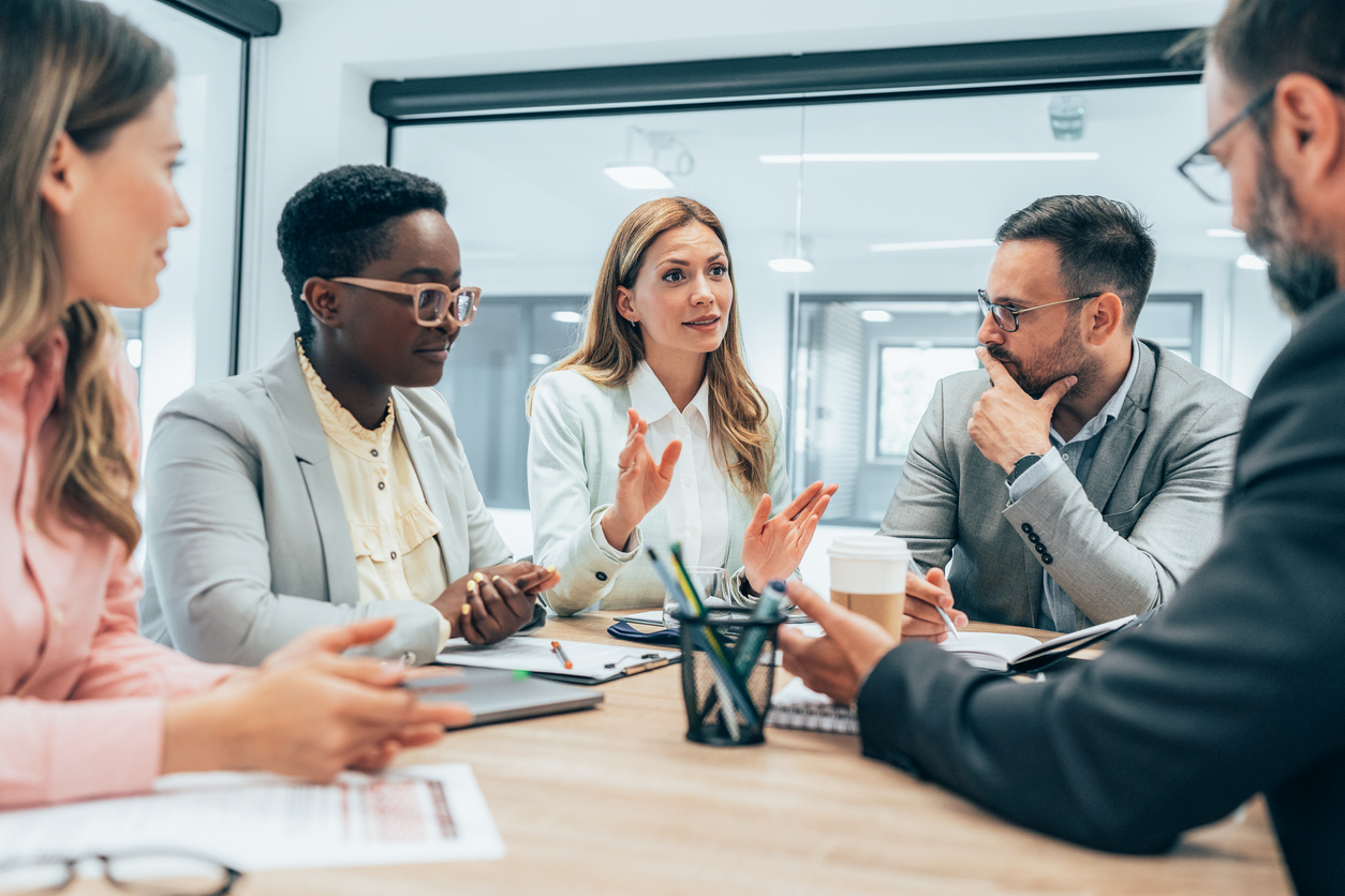 Modern business team discussing new ideas at the office. Business people on meeting in modern office. Colleagues smiling and talking at board room. Brainstorming. NBCUniversal had a campaign to spread awareness about COVID.